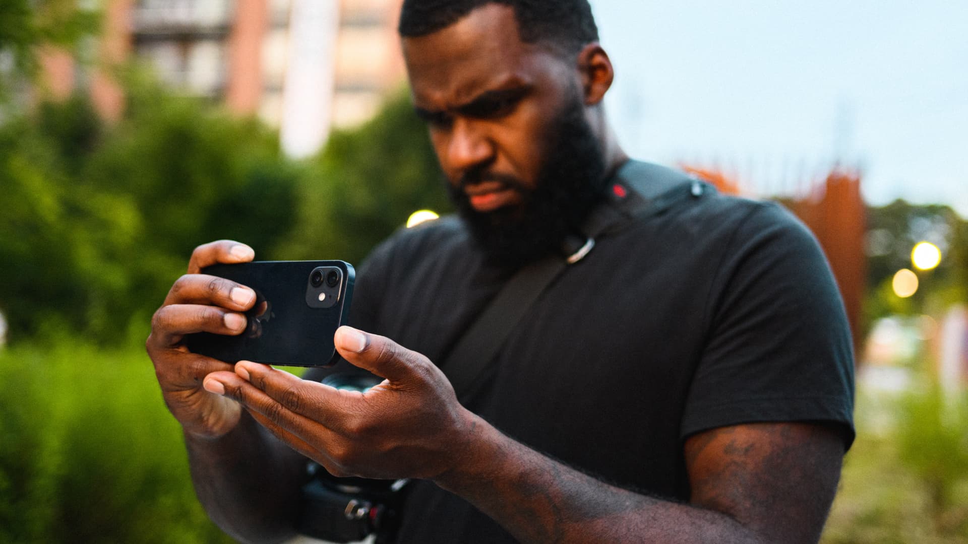 André Davis framing a shot on his phone with a camera rig at his side.